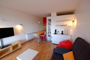 a living room with a couch and a table and a kitchen at Le Balcon de Valberg in Valberg