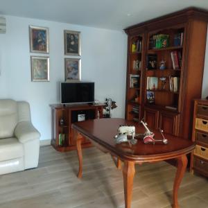 sala de estar con mesa de centro y TV en Villa 28 de julio Casa Rural con piscina en Granada en Granada