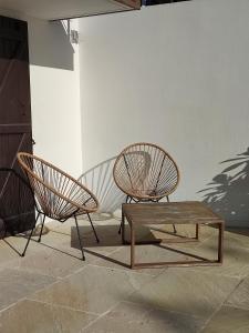 two chairs and a wooden table next to a wall at Maison Caiada in Urrugne