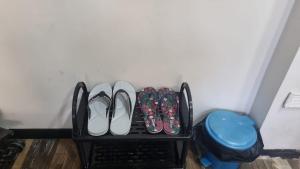 a shelf with pairs of shoes and a blue trash can at Terrace Garden in Hyderabad