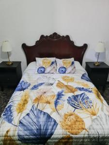 a bed with a floral comforter and pillows on it at Aguatona in Ingenio