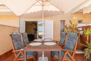 a table and chairs with an umbrella on a patio at Apartment near the beach in Gran Alacant