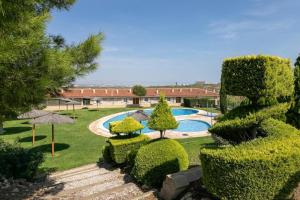 a garden with a swimming pool and trees and bushes at Apartment near the beach in Gran Alacant