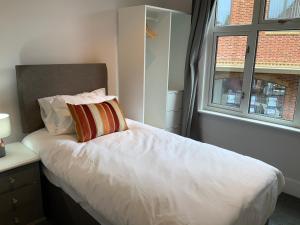 a bedroom with a white bed with a window at Stylish 2 Bedroom Cottage in Bishop's Stortford by BookedUK in Stansted Mountfitchet