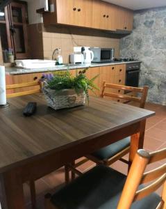 cocina con mesa de madera con sillas y fregadero en The cave apartment, en Potamitissa