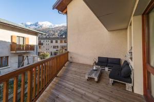 einen Balkon mit einem Sofa und einem Couchtisch in der Unterkunft Norberts Place in Lanslevillard