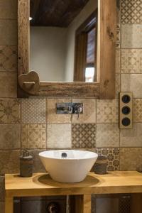 ein Badezimmer mit einem weißen Waschbecken und einem Spiegel in der Unterkunft Norberts Place in Lanslevillard