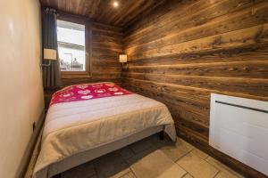 1 dormitorio con 1 cama en una cabaña de madera en Norberts Place, en Lanslevillard