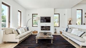 a living room with white furniture and a fireplace at Hesperia - San Jose in Sant Josep de sa Talaia