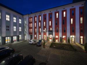 ein großes Gebäude mit Autos auf einem Parkplatz in der Unterkunft EA Business Hotel Jihlava in Jihlava