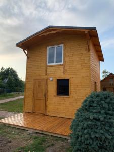 a tiny house on a wooden deck at Domki Pod Lasem in Mrzeżyno