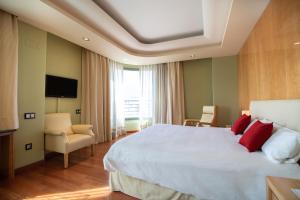 una habitación de hotel con una cama grande con almohadas rojas en Alda Mirador del Moncayo, en Ólvega