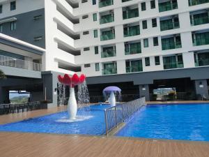a swimming pool with two fountains in front of a building at Nur Mateen's Studio - Vista Bangi Service Apartment in Kajang