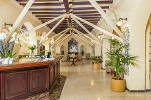 un gran vestíbulo con un techo artesonado y plantas en Hotel Guitart Rosa - Adults Only, en Lloret de Mar