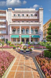 un gran edificio con flores delante en Hotel Guitart Rosa - Adults Only, en Lloret de Mar