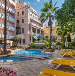 un hôtel avec une piscine en face d'un bâtiment dans l'établissement Hotel Guitart Rosa - Adults Only, à Lloret de Mar
