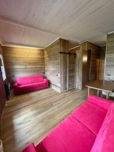 a room with a pink couch and wooden walls at Panorama Chalet a La Grand'Ourse di Cervinia CIR VDA Valtournenche 0198 in Breuil-Cervinia