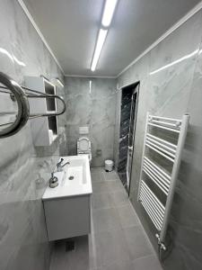 ein Badezimmer mit einem weißen Waschbecken und einem WC in der Unterkunft Vila Lika in Korçë