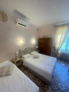 Cette chambre comprend 2 lits et une fenêtre. dans l'établissement Hotel Villa Provencale, à Cavalaire-sur-Mer