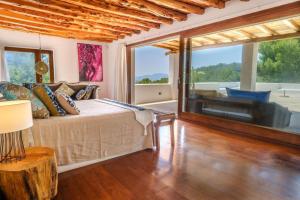a bedroom with a bed and a large window at Can Sabina - San Antonio in Santa Agnès de Corona