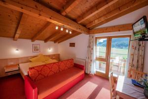 1 dormitorio con cama, sofá y ventana en Landhaus Hofer, en Neustift im Stubaital