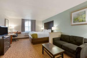 a hotel room with a bed and a couch at Quality Inn Alexis Rd in Toledo