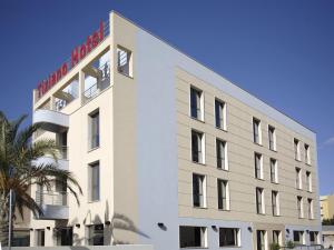Biały budynek z czerwonym napisem w obiekcie Hotel Tiziano w Trapani