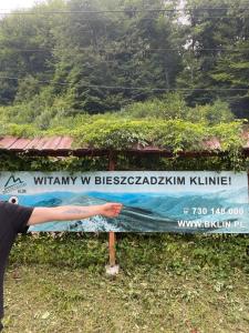 a person is standing in front of a sign at Bieszczadzki Klin BKLIN in Cisna
