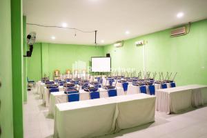 a room with rows of chairs and a screen at Hotel Ratu Ayu 2 Lampung Mitra RedDoorz in Tanjungkarang