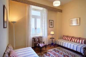 a living room with two beds and a window at Doma Hotel in Chania Town