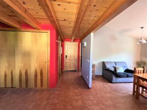 un soggiorno con divano e soffitto in legno di La Vall Apartaments Dúplex a Sant Llorenç de Morunys