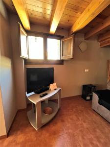 sala de estar con TV y escritorio con TV en La Vall Apartaments Dúplex, en Sant Llorenç de Morunys