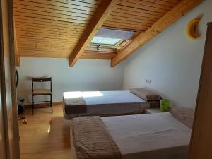 - une chambre avec deux lits et un plafond avec une lucarne dans l'établissement El Mirador de la Sierra, à Benaocaz