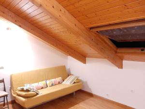 un sofá en una sala de estar con techos de madera. en El Mirador de la Sierra en Benaocaz