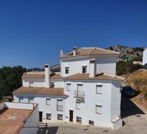 貝瑙卡斯的住宿－El Mirador de la Sierra，一座白色的建筑,上面设有一个阳台