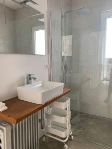 La salle de bains est pourvue d'un lavabo blanc et d'une douche. dans l'établissement Casa Al Fianco - Brand new house with a breathtaking view, à Petacciato