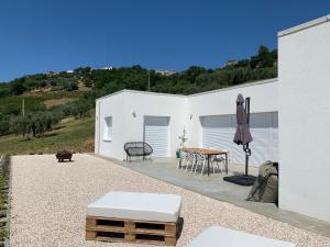 a white building with a table and an umbrella at Casa Al Fianco - Brand new house with a breathtaking view in Petacciato