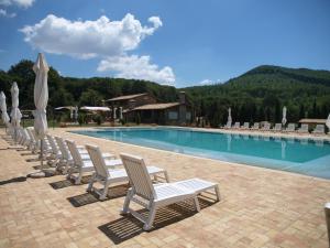 uma fila de cadeiras sentadas ao lado de uma piscina em Residenza di Rocca Romana Holiday Home em Trevignano Romano