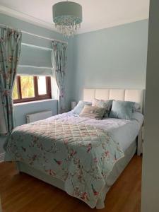 a bedroom with a bed and a chandelier at Spacious 2 BR home close to town & coast + parking in Uzmaston