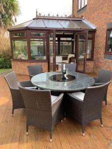 a glass table and chairs on a patio at Spacious 2 BR home close to town & coast + parking in Uzmaston