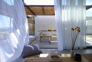 梅西尼的住宿－Bouca Houses，客厅配有白色窗帘和桌子