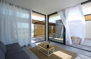 un soggiorno con divano e ampie finestre di Bouca Houses a Messini