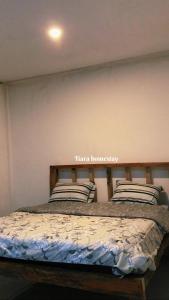 PlambiにあるTiara Homestayのベッドルーム1室(壁に看板付) +21枚の写真
