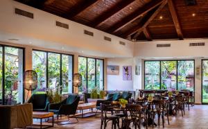 a restaurant with chairs and tables and windows at Hagoshrim Hotel & Nature in HaGoshrim