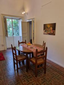 uma sala de jantar com uma mesa de madeira e cadeiras em Palazzo Mannino Apartments em Catânia