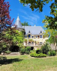 a large house with a turret on top of a yard at Beautiful Château with Private Pool near Cahors in Cambayrac