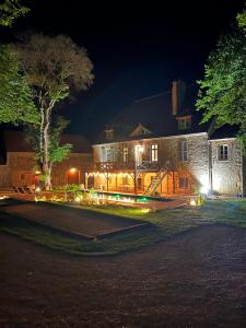 uma casa iluminada à noite com luzes em Les Chambres du parc 