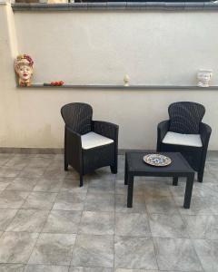 two chairs and a table in a waiting room at AEROPORTO KATANÈ ROOMS in Catania