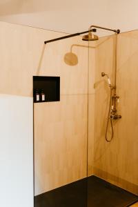 uma casa de banho com um chuveiro e uma porta de vidro em Les Chambres du parc 