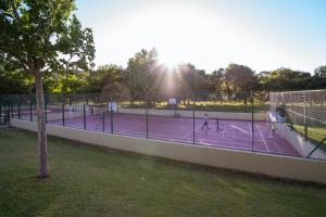 un grupo de personas jugando al tenis en una pista de tenis en Kampaoh Mendigorría en Mendigorría